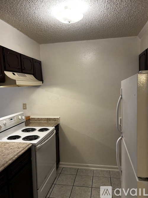 A small kitchen with a stove and refrigerator.