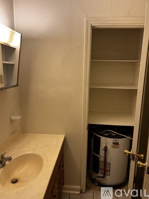 A bathroom with a sink and a doorway leading to a utility room.