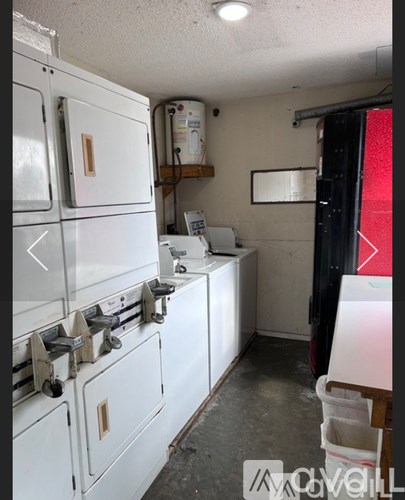 A white stove top oven with a white fridge in a kitchen.