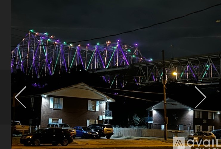 A bridge with purple lights is lit up at night.