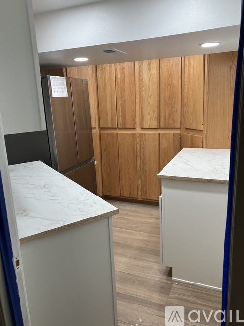 A kitchen with wooden cabinets and a marble countertop.