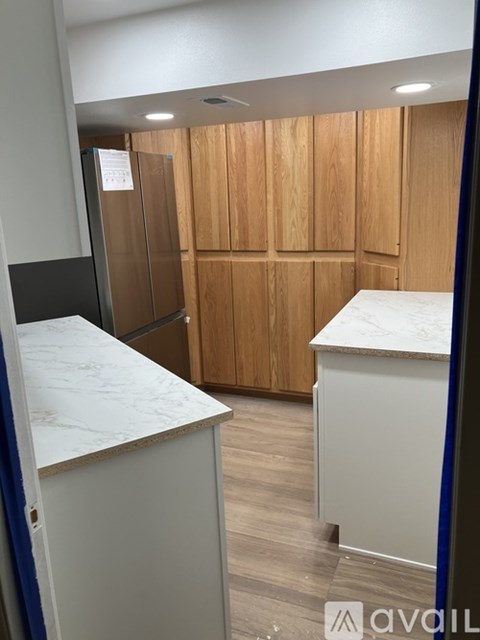 A kitchen with wooden cabinets and a marble countertop.