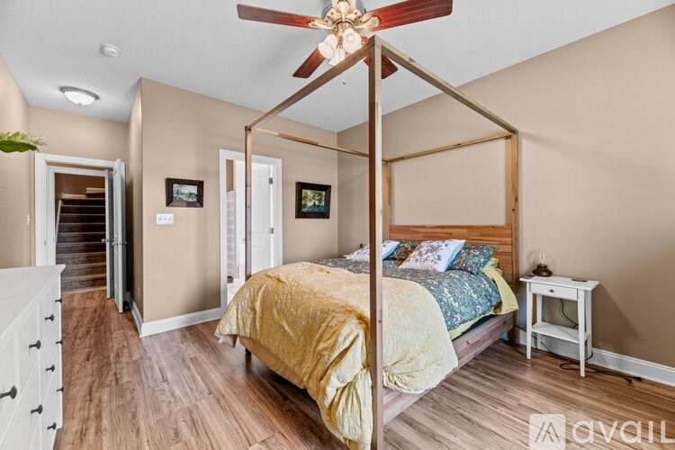 A bedroom with a four poster bed and a ceiling fan.