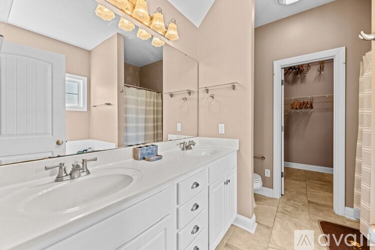 A bathroom with a white sink and a large mirror.