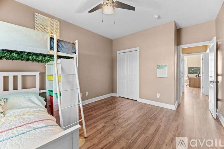A bedroom with a bunk bed and a ceiling fan.
