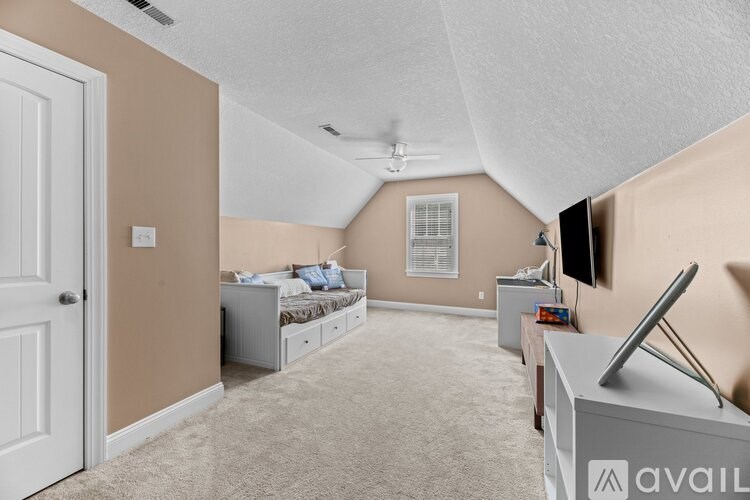 A bedroom with a bed, dresser, and television.