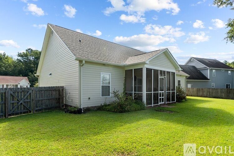 A house with a fence and a green lawn in front.