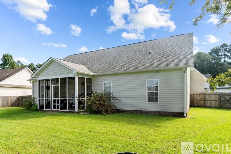 A house with a grey roof and a white wall with a glass door.