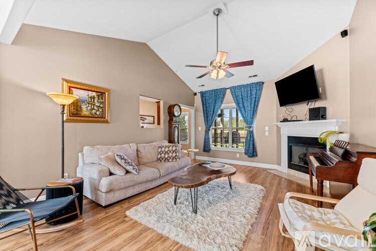 A living room with a white couch, a coffee table, and a ceiling fan.
