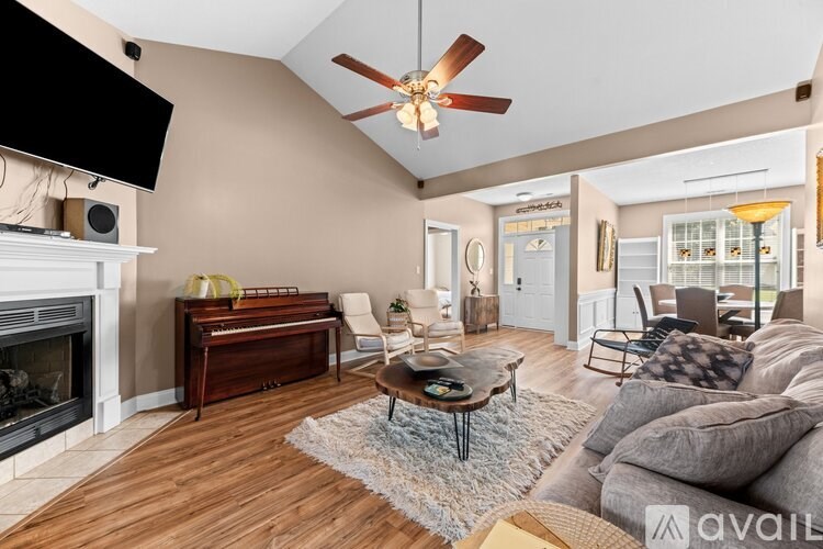 A living room with a piano and a fireplace.