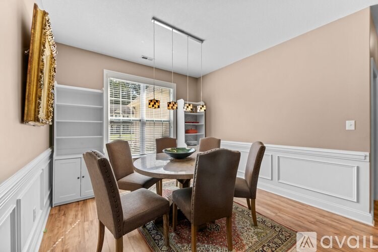 A dining room with a table and chairs.