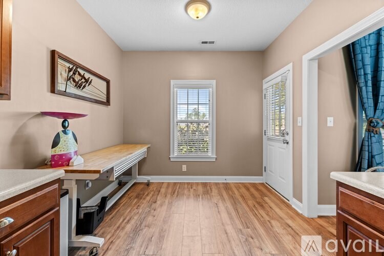 A room with a window and a wooden floor.
