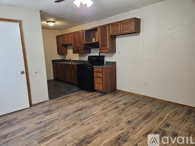 A kitchen with wooden cabinets and a black stove top oven.