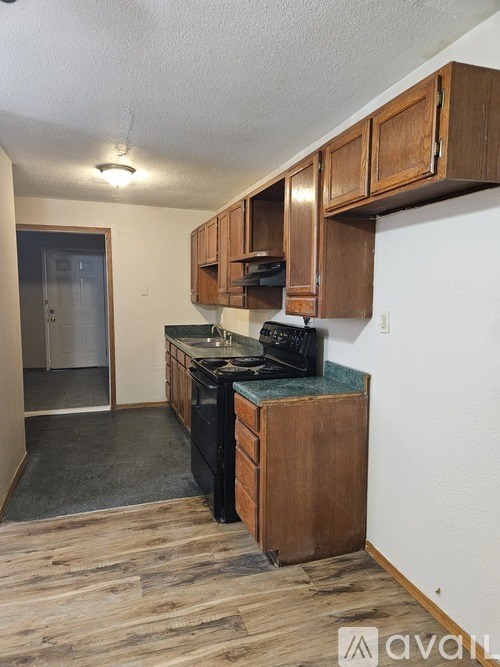 A kitchen with wooden cabinets and a black countertop.