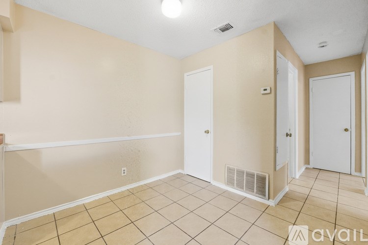 A room with beige walls and a tiled floor with a white trim.