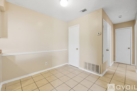 A room with beige walls and a tiled floor with a white trim.