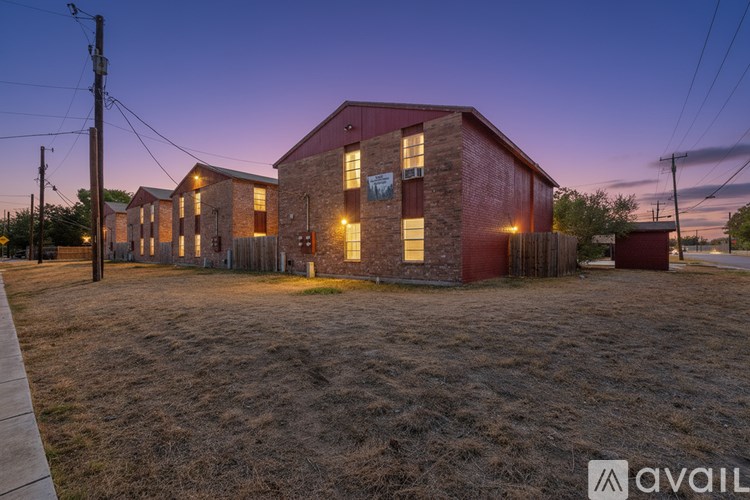 A building with a red roof and a sign that says "available" is lit up at dusk.