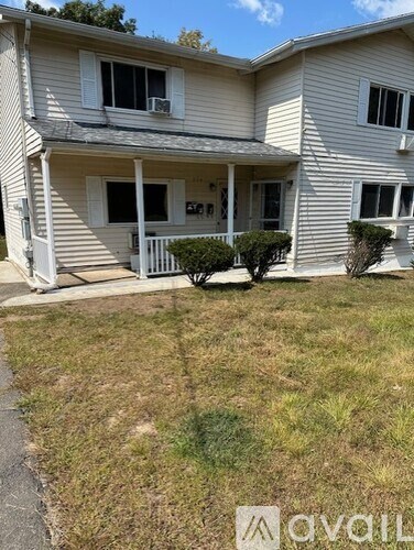 A two-story house with a balcony and a small front yard.