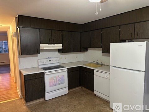 A kitchen with black cabinets and white appliances.