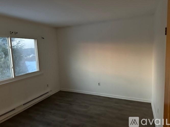 A sparsely furnished room with a large window.