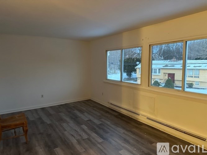 A room with a wooden floor and a window showing a snowy scene outside.