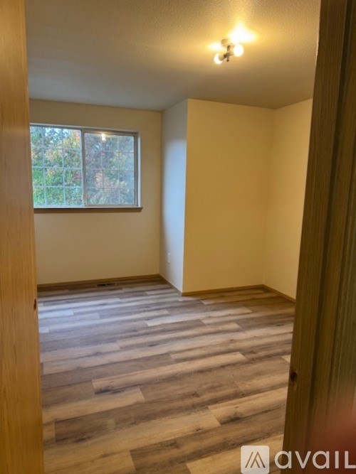 A room with wooden flooring and a window.