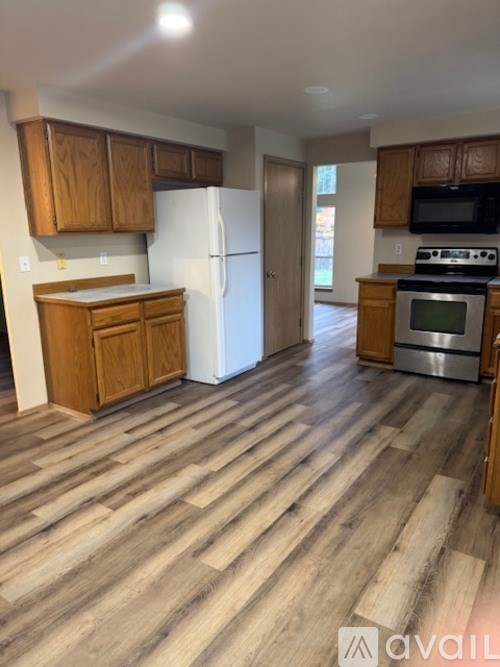 A kitchen with wooden cabinets and a white refrigerator.