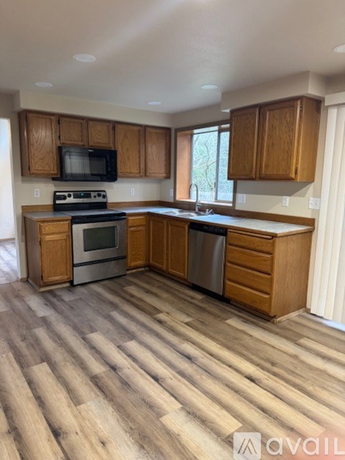 A kitchen with wooden cabinets and a stainless steel dishwasher.