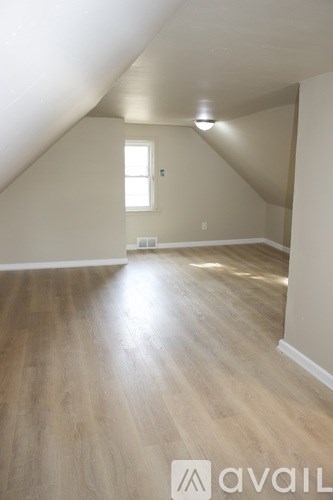 A room with wooden flooring and a window.