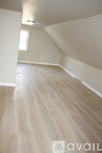 A room with wooden flooring and a window.