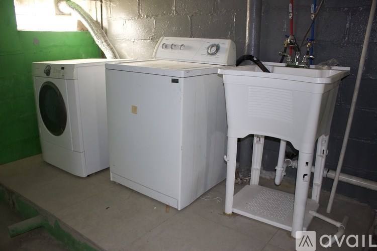 A white washing machine and dryer are on a concrete floor.