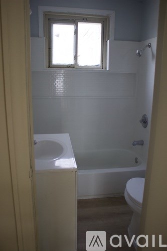 A bathroom with a toilet, sink and bathtub.
