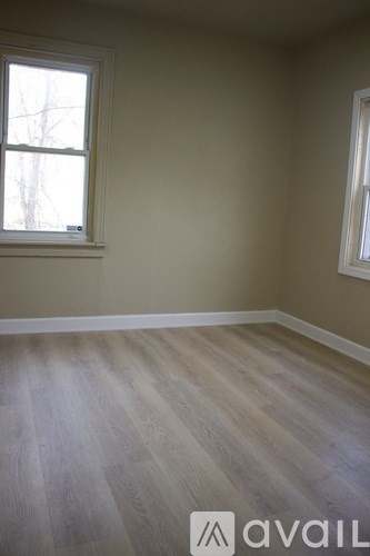 A room with a window and wooden flooring.