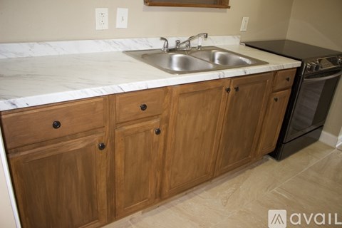 A kitchen with wooden cabinets and a marble countertop.