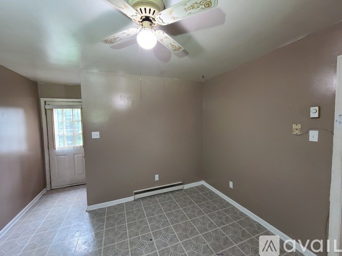 A room with a ceiling fan and tile flooring.