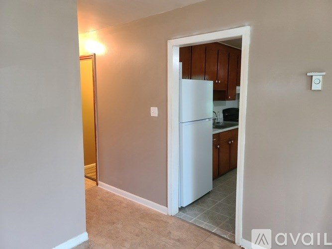 A kitchen with a white refrigerator and wooden cabinets.