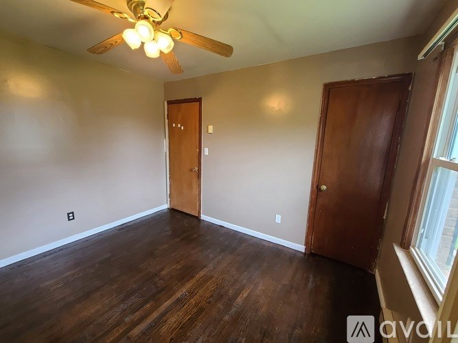A room with wood floors and a ceiling fan.