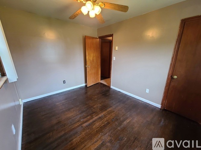 A room with wooden floors and a ceiling fan.