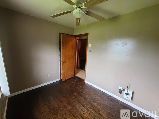 A room with a ceiling fan and a door.