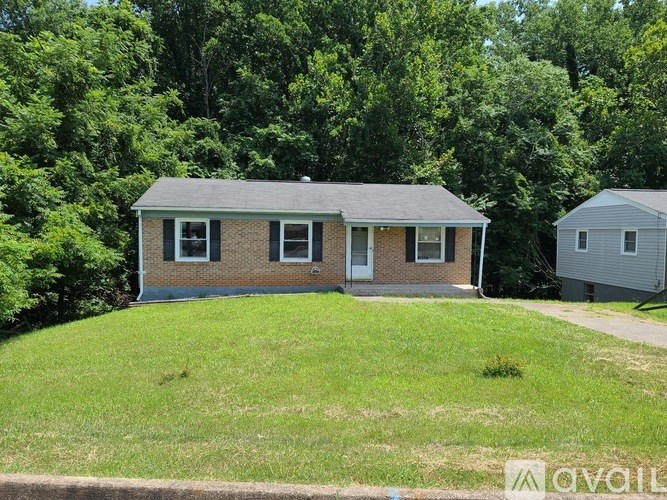 A house with a grey roof is surrounded by greenery.