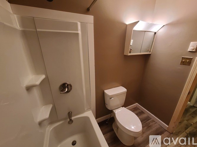 A white toilet sits in a small bathroom next to a white sink.