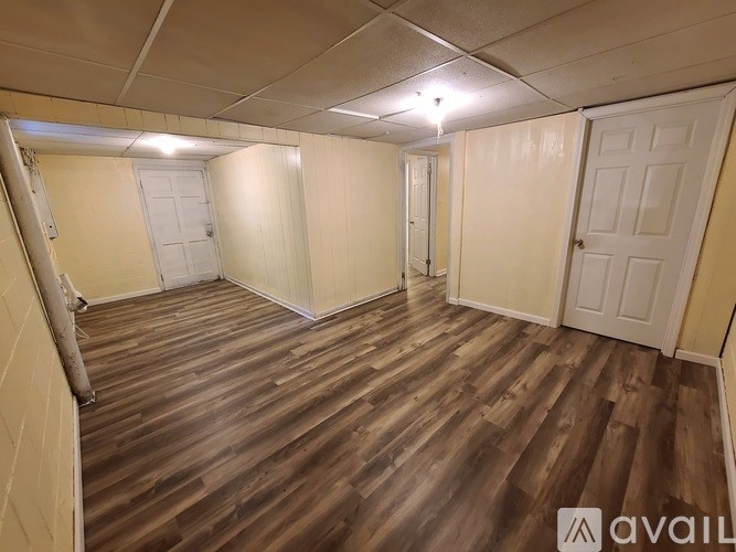 A room with wooden flooring and white doors.