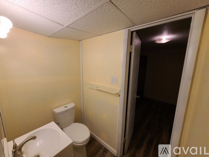 A bathroom with a toilet, sink, and a door.