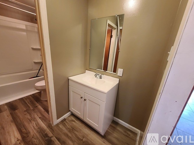 A bathroom with a white cabinet and a mirror.