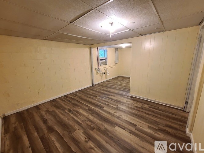 A room with wooden flooring and white walls.