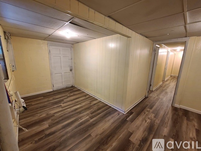 A room with wooden flooring and white walls.