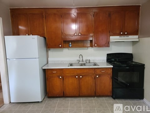 A kitchen with wooden cabinets and a white fridge.