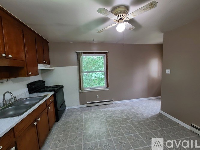 A kitchen with brown cabinets and a black stove top oven.