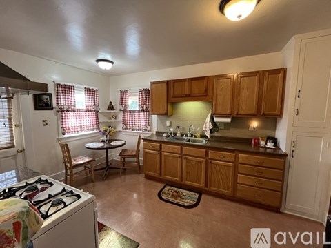 A kitchen with wooden cabinets and a white stove top oven.