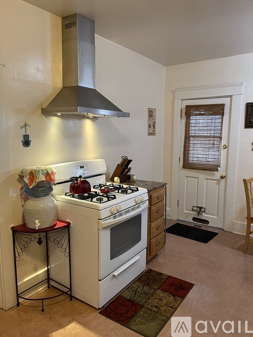A kitchen with a stove and a hood.